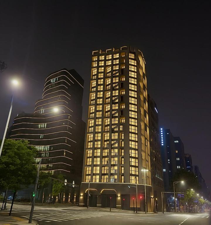 a tall building with lights on it at night at Caelum Black Gangnam Luxury Residence in Seoul