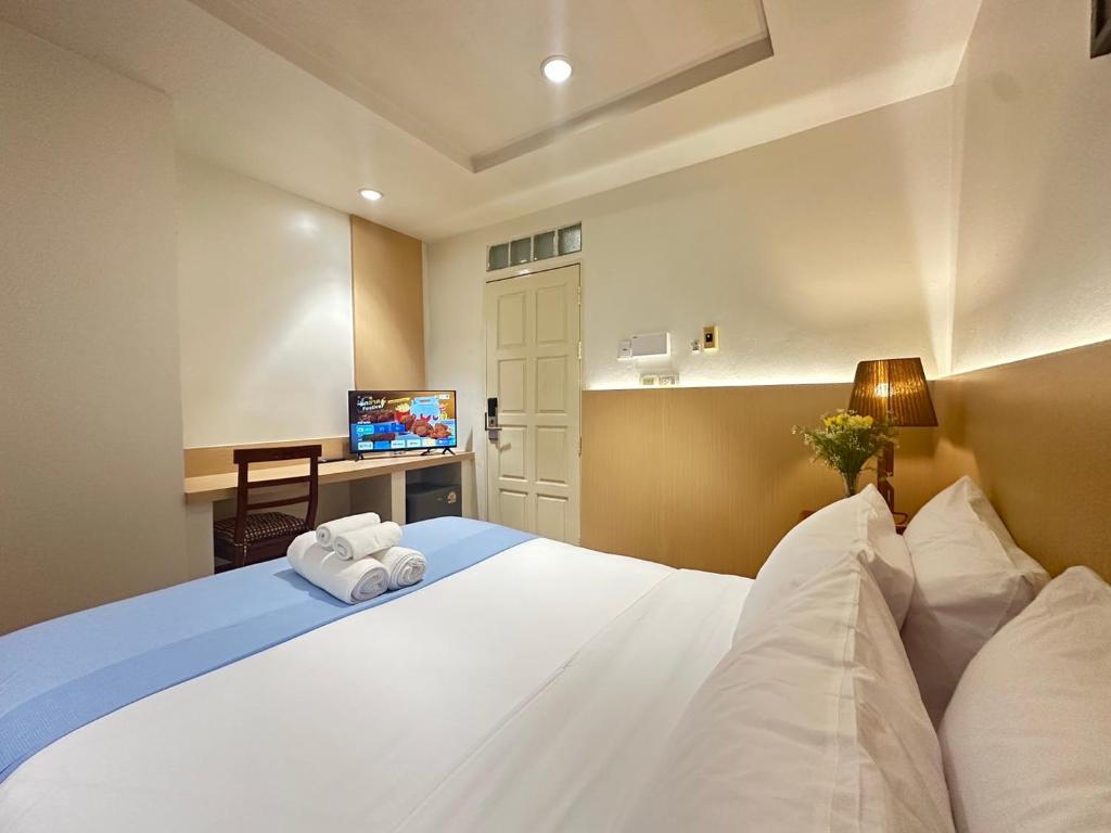 a bedroom with a large white bed and a television at Yukata Space 