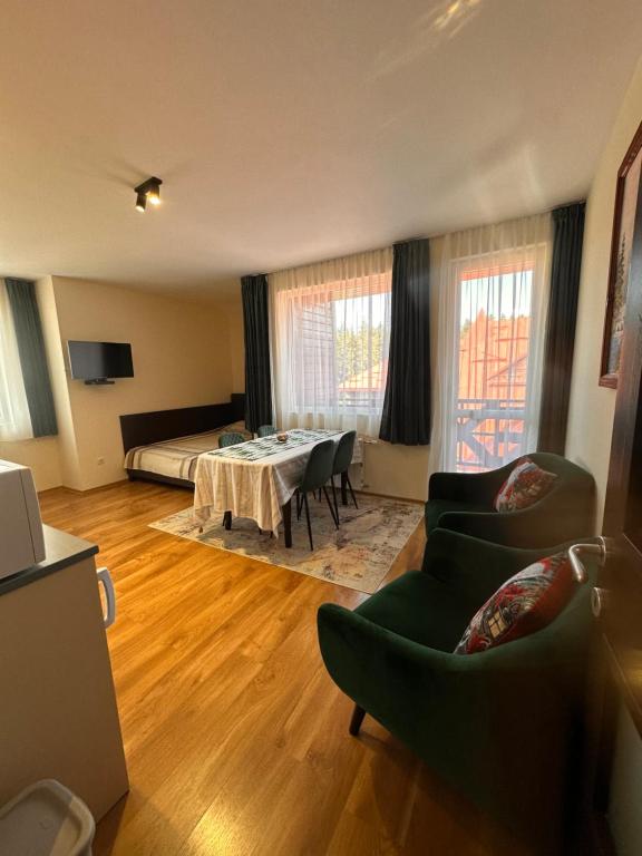 Una sala de estar con una cama, una mesa y sillas. en Private large apartment in Iglika 2 for 4 people, en Borovets