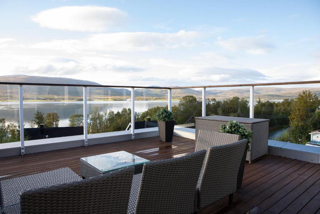 a balcony with chairs and a table and a view of the water at Arctic Panorama in Tromsø