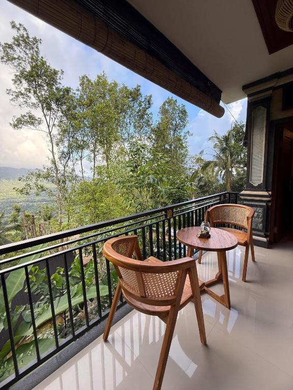 a balcony with two chairs and a table at D'Labake Guest House in Sidemen