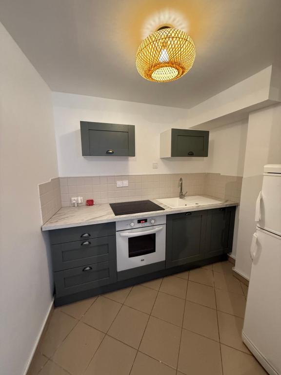 Una cocina con estufa, fregadero y refrigerador. en MAX1 T2 avec terrasse Nouvelle rénovation octobre 2025, en Saint-Valéry-en-Caux