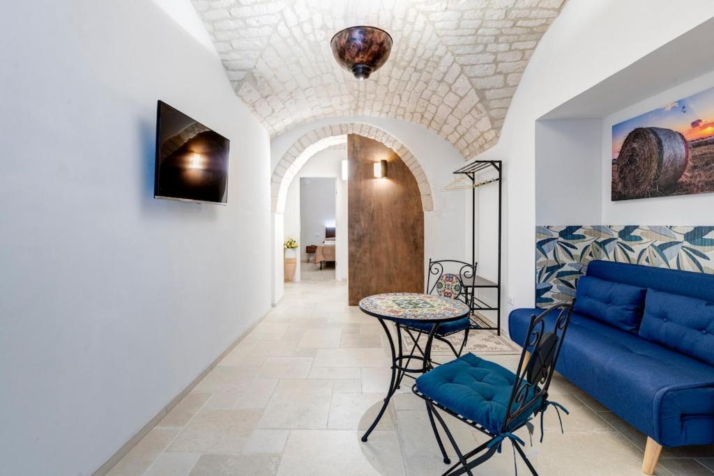a living room with a blue couch and a table at Lanucara 6 in Martina Franca