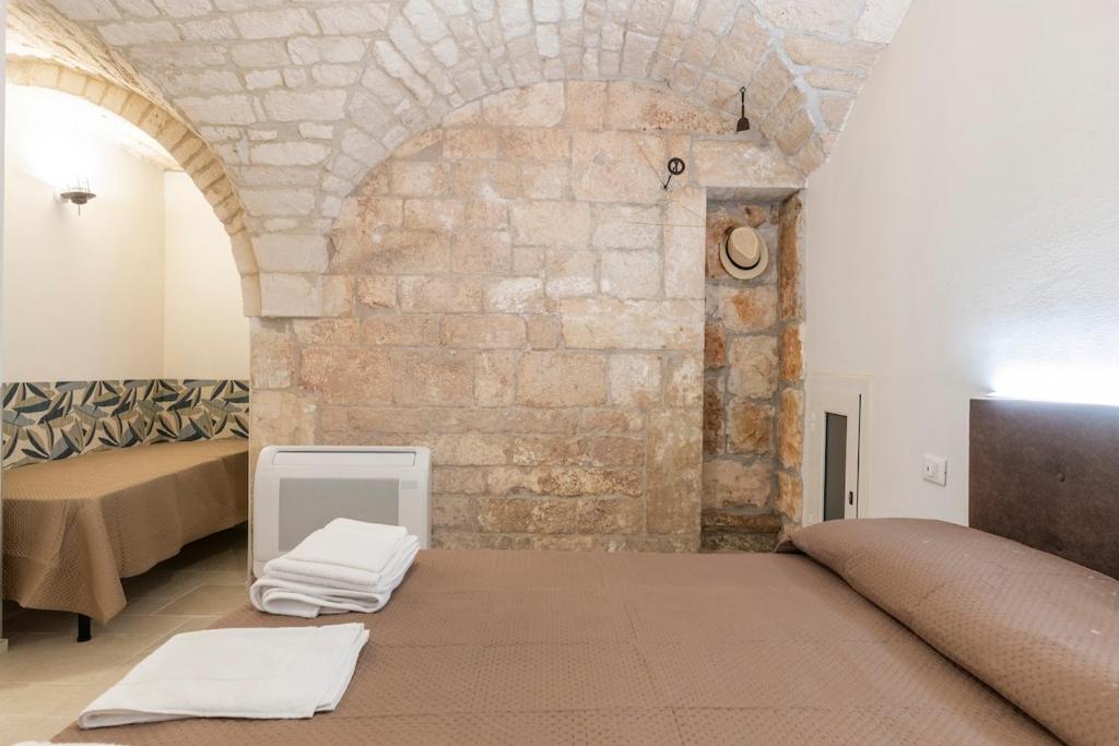 een kamer met een bed en een stenen muur bij Lanucara 6 in Martina Franca