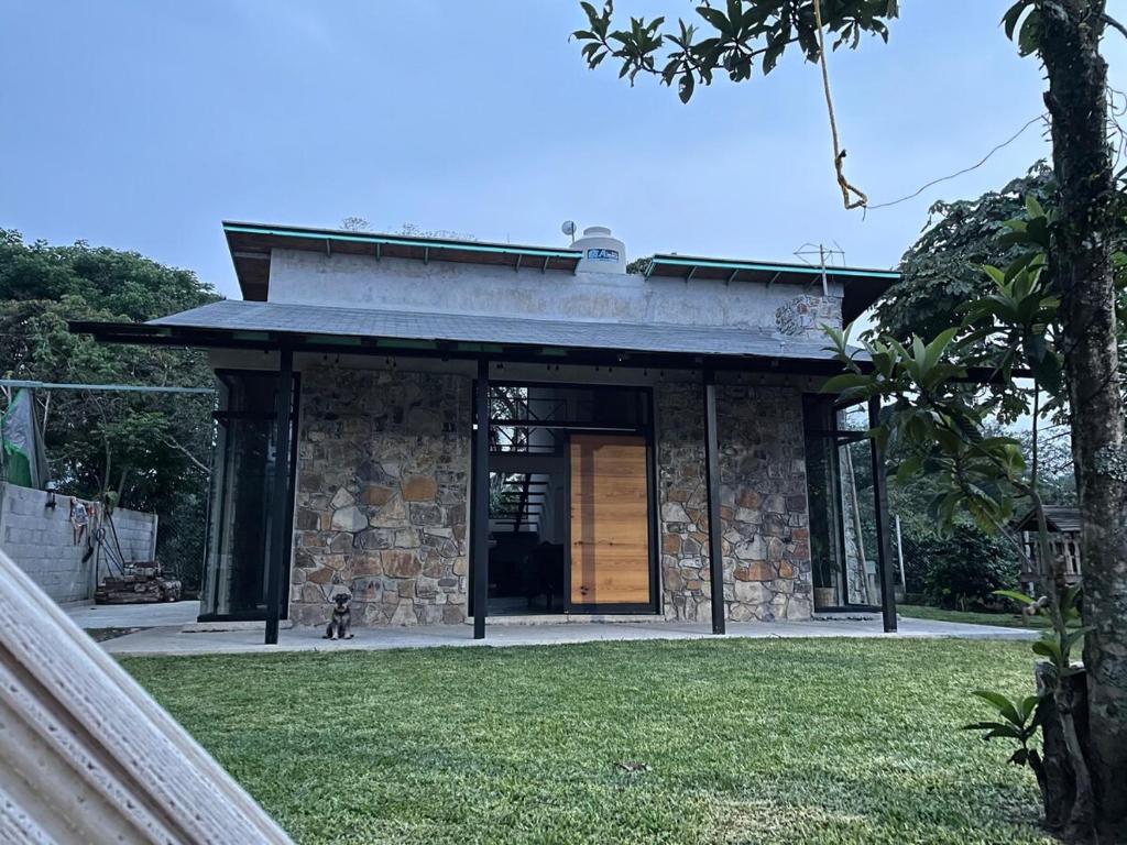 a stone house with a door in a yard at Cabaña en cafetales de Huatusco 