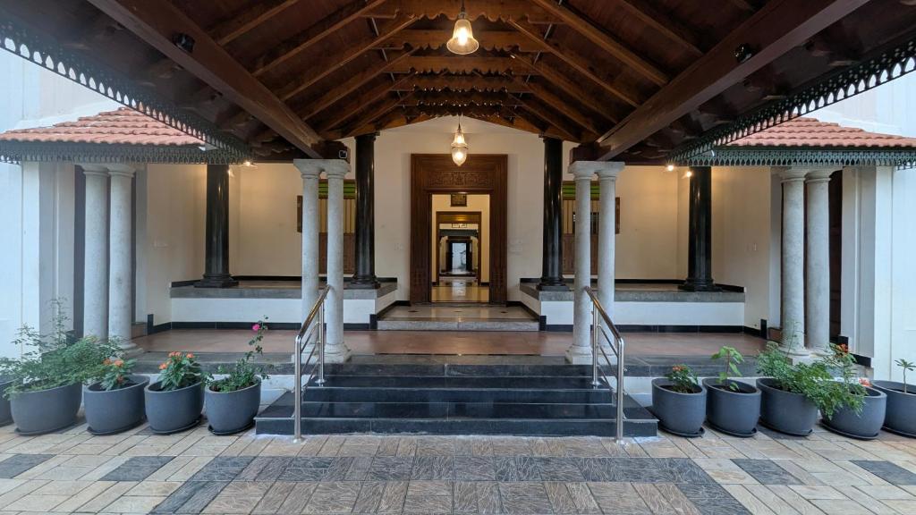 a lobby of a building with potted plants at Saranyam by LuxUnlock Private Villas in Kāraikkudi