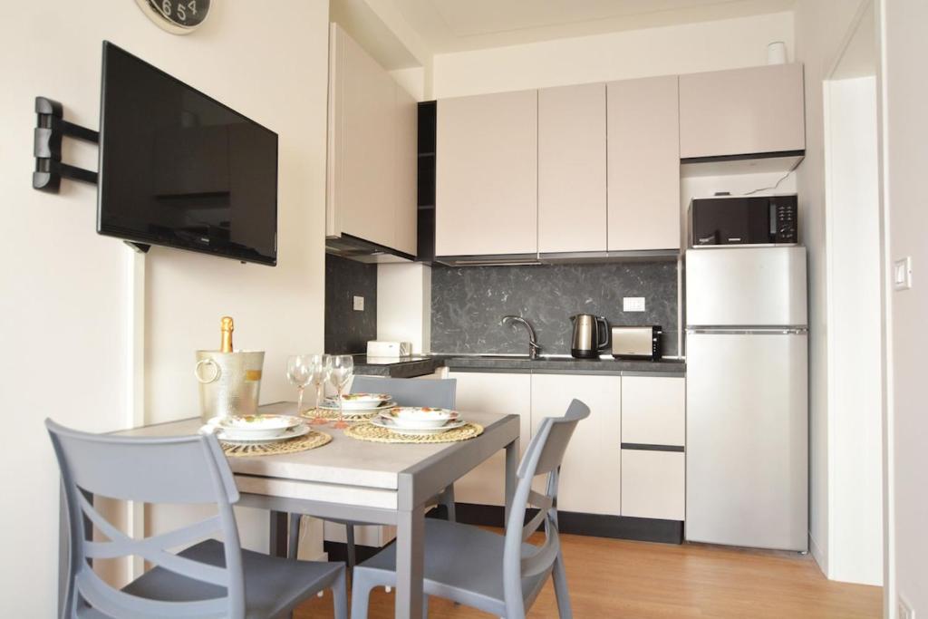 une cuisine avec une table avec des chaises et un réfrigérateur dans l'établissement At the Tito Livio Passage - between history and modernity, à Padoue