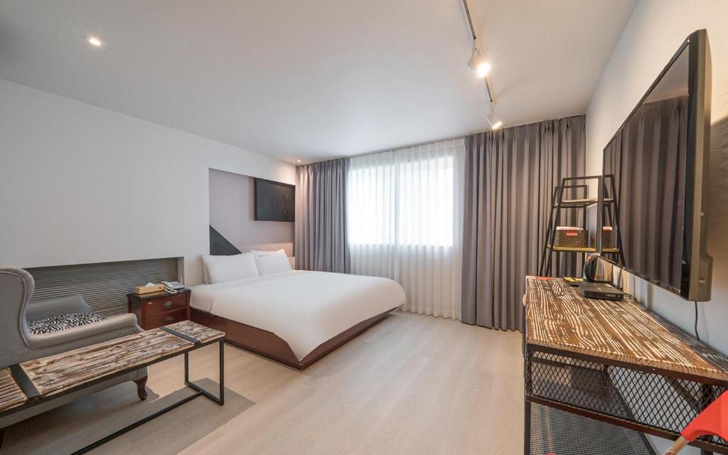 een hotelkamer met een bed en een stoel bij Song-Jeong Bay Hotel in Busan