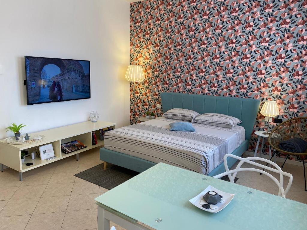 Hotel Bruna's Studio, a bedroom with a bed and a wall with a wallpaper at Bruna's Studio in Bologna