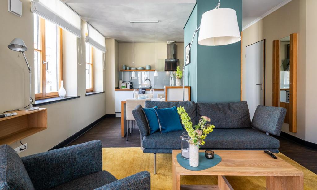 a living room with a couch and a table at THE GREEN Rostock Apartment Hotel in Rostock