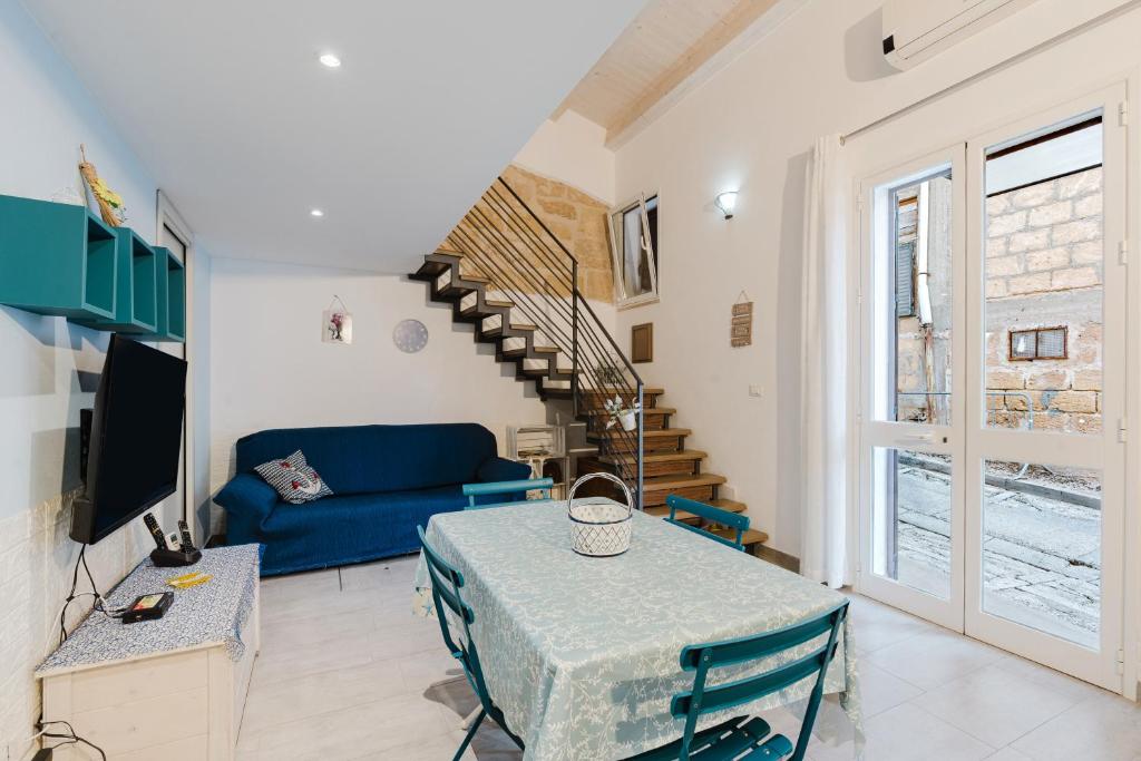 a living room with a blue couch and a table at Casa del Golfo in Castellammare del Golfo
