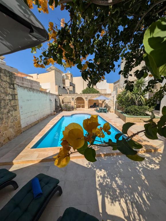 a swimming pool in front of a house at Gozitan Charm in Xaghra with Pool in Xagħra