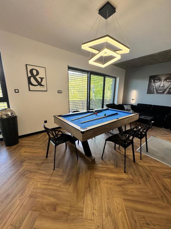 a room with a ping pong table and chairs at SPA Apartament Wisła prywatna sauna, jacuzzi i bilard in Wisła