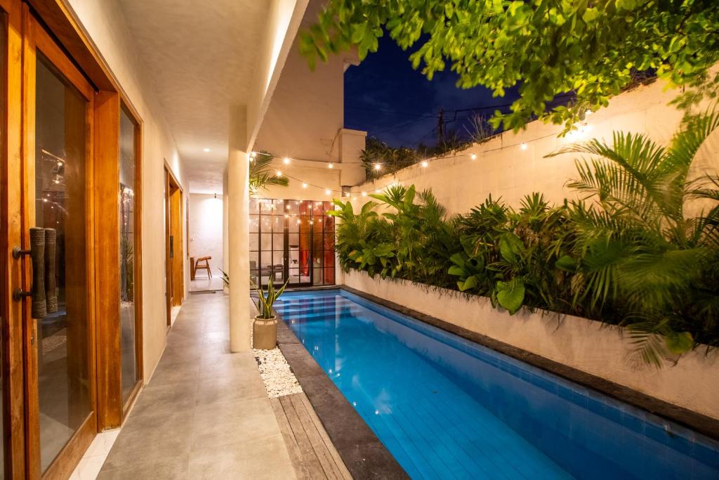 a swimming pool in a house with plants at Casa Ombak in Kerobokan
