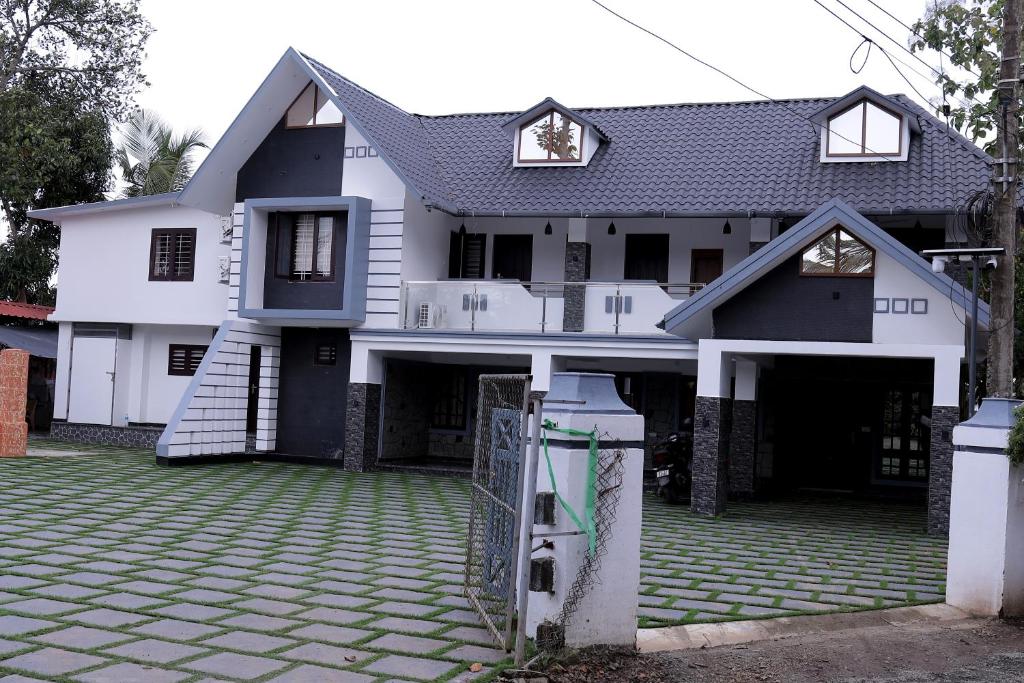 una casa blanca con una puerta delante de ella en Georges Lakeview Resort, en Tiruvalla
