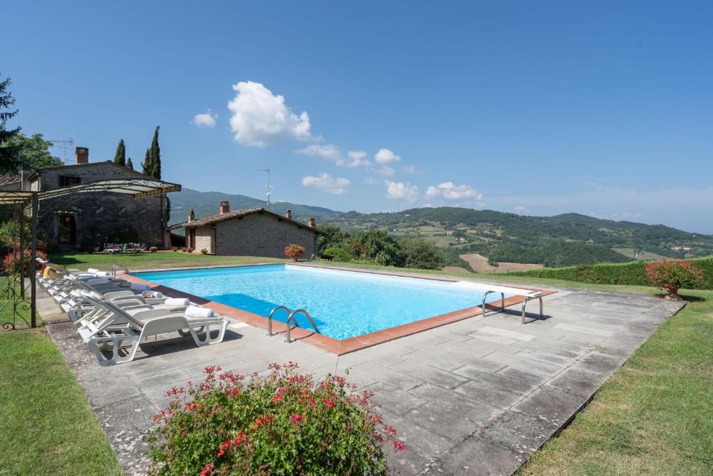 Una gran piscina con sillas y una casa. en Villa La Terrazza, en Ampinana