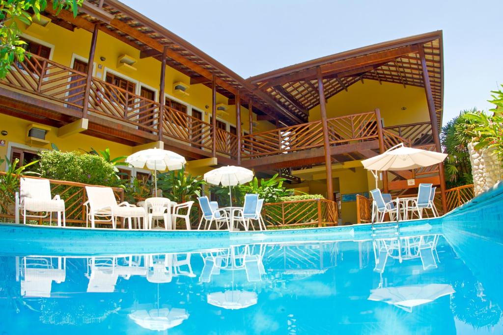 ein Resort mit einem Pool mit Stühlen und Sonnenschirmen in der Unterkunft Pousada Maui in Ubatuba