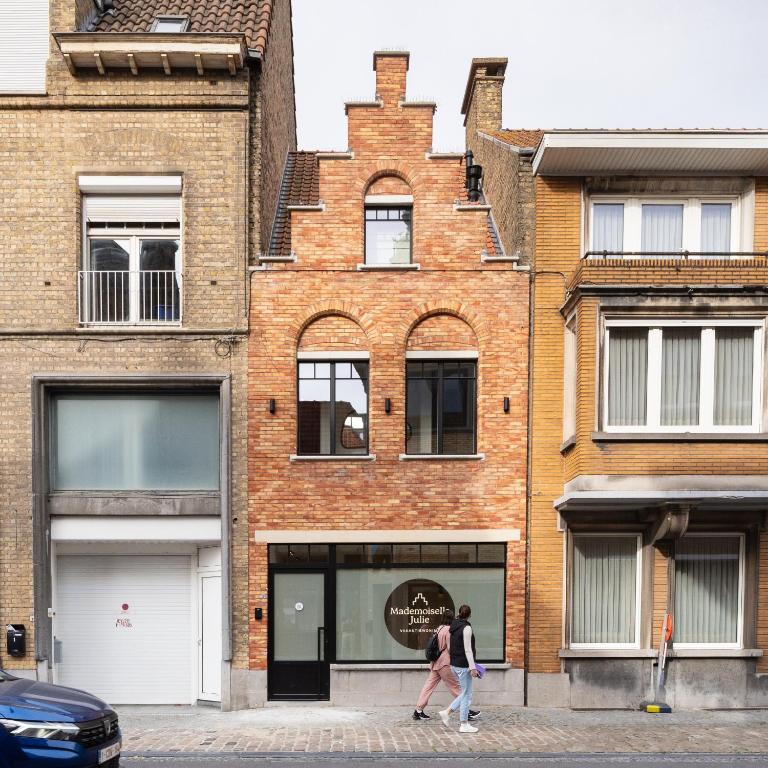 two people walking in front of a building at Mademoiselle Julie in Diksmuide