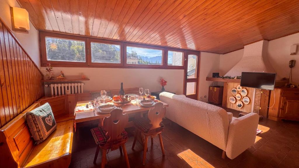 a living room with a table and chairs and a couch at Residenza Marmarole by Ca-Sa Check in Pieve di Cadore