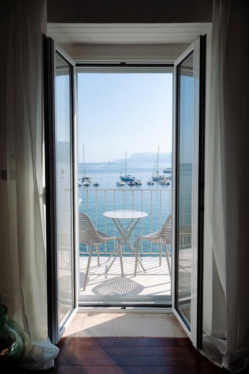 a balcony with a table and a view of the water at Radici 1937 - Lodge sul mare in Scilla