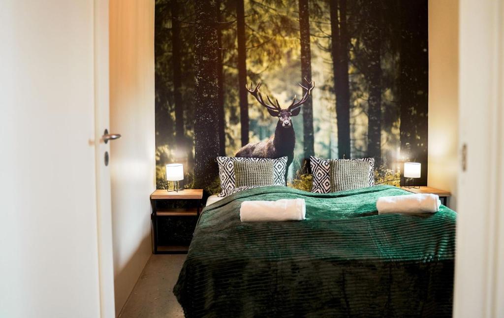 a bedroom with a bed with a deer on the wall at Domki Natura Zator in Graboszyce