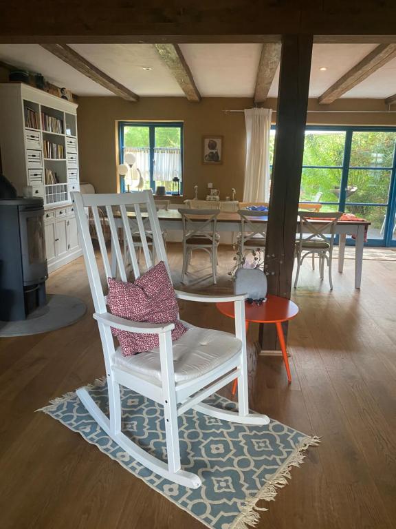 a white rocking chair sitting in a living room at Ferienhaus an der Ostsee mit großem Garten in Rerik