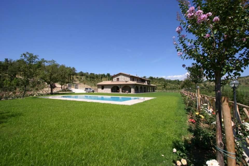 een tuin met een zwembad en een huis bij La Frontiera in San Feliciano