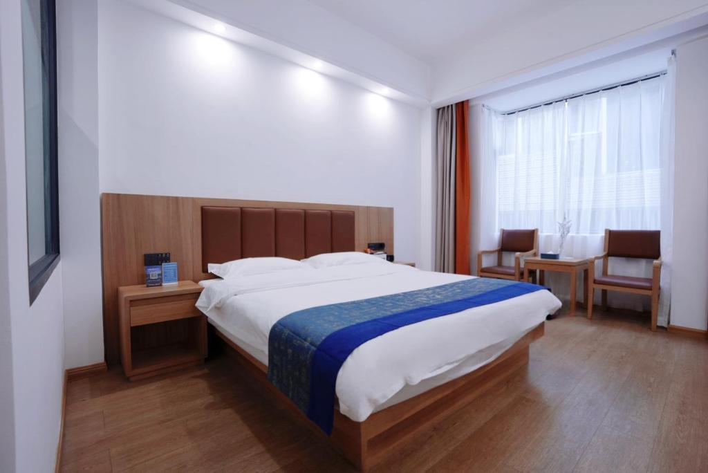 Un dormitorio con una cama grande y una mesa y sillas. en Lingli Home Hotel, en Dali