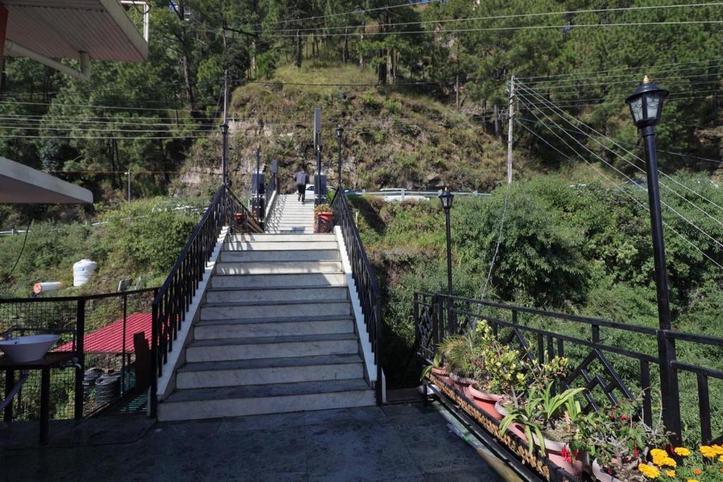 a staircase leading up to a hill with flowers at Swastik Inn in Jāmb