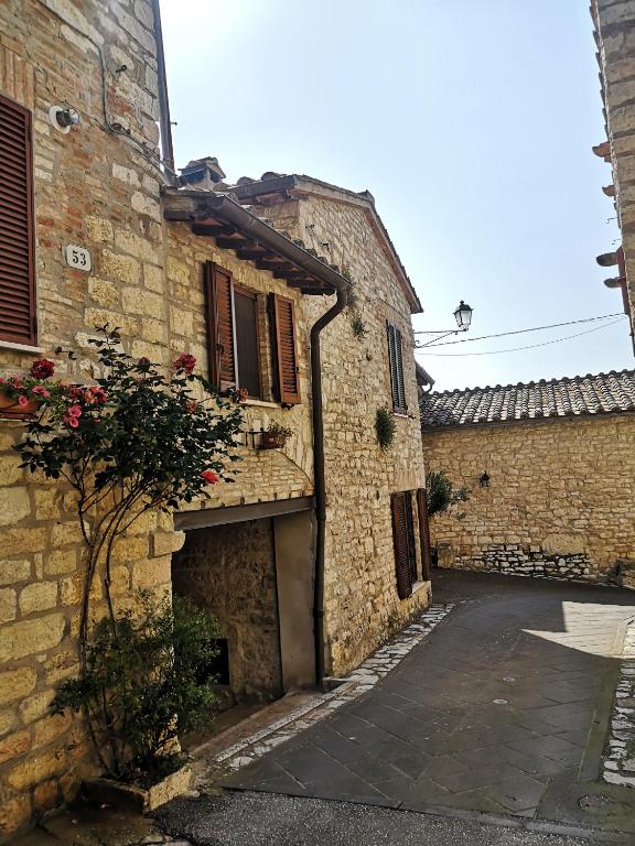 an alley in an old stone building with a garage at La casa sull'archetto in Corciano