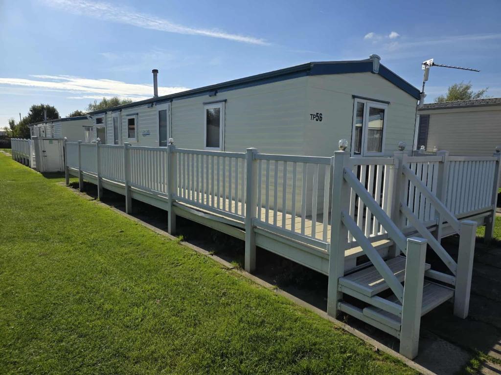 a row of mobile homes parked next to a fence at 8 Berth 3 bed caravan pet friendly TP56 in Chapel Saint Leonards