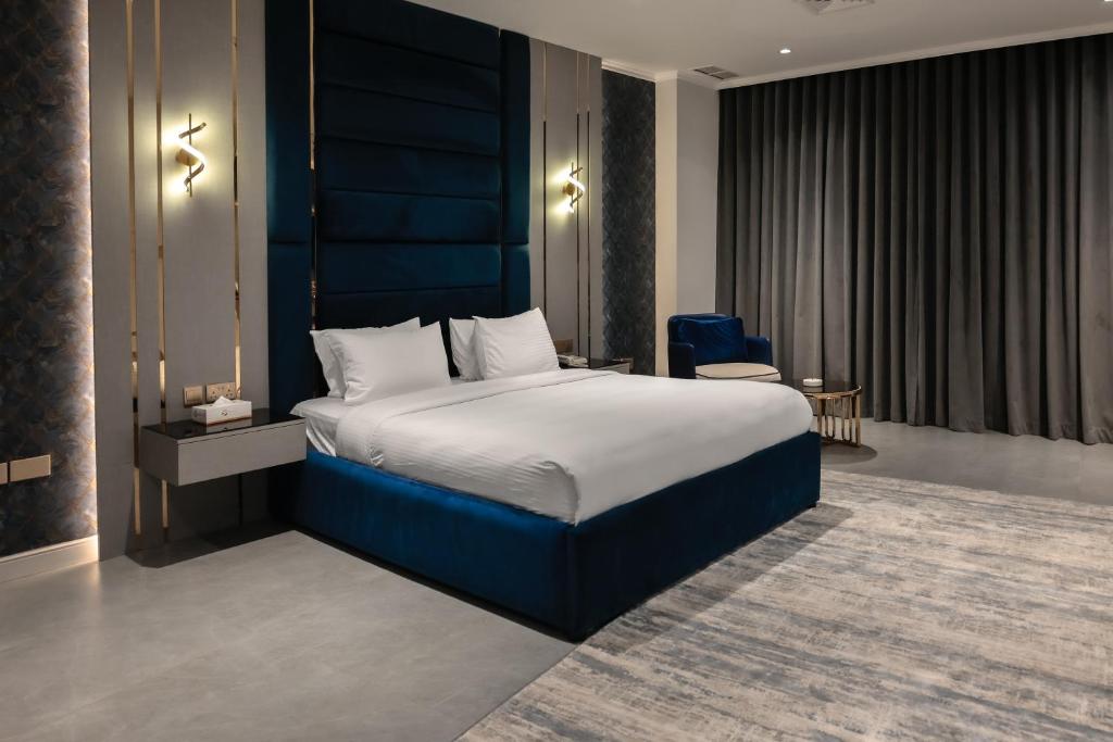 a bedroom with a large bed with a blue headboard at Palazzo hotel in Kuwait