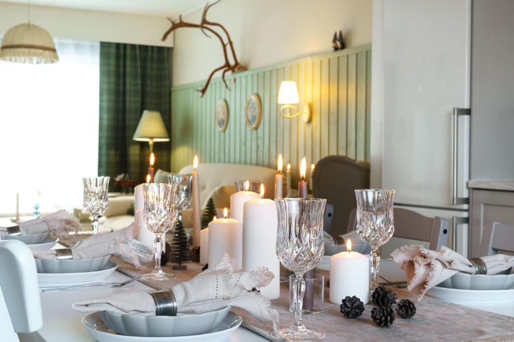 - une table à manger avec des bougies et des verres à vin dans l'établissement Reindeerly Cottage Hosted by Hygge Host, à Rovaniemi