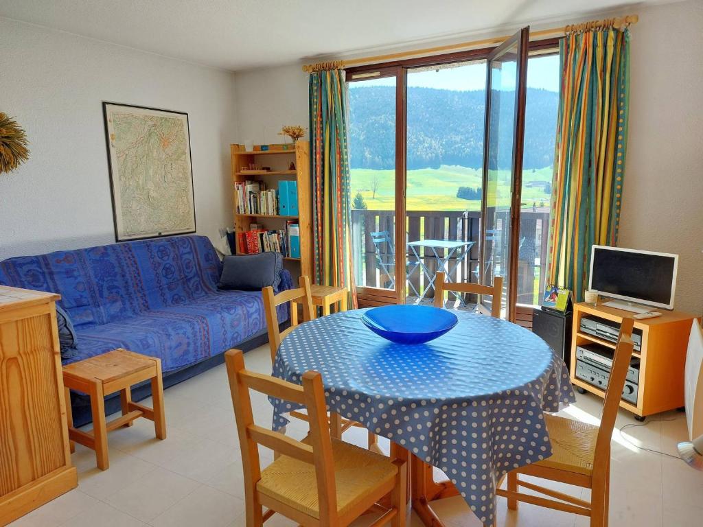 a living room with a table and a couch at Appartement cosy à Méaudre - 2 chambres, 5 pers, parking, lave-linge - FR-1-737-39 in Méaudre