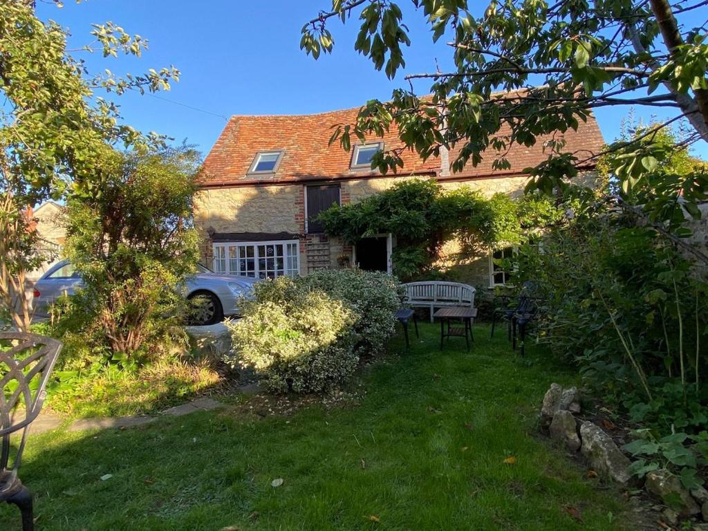 a house with a car parked in the yard at The Barn - Wheatley - Oxford in Wheatley