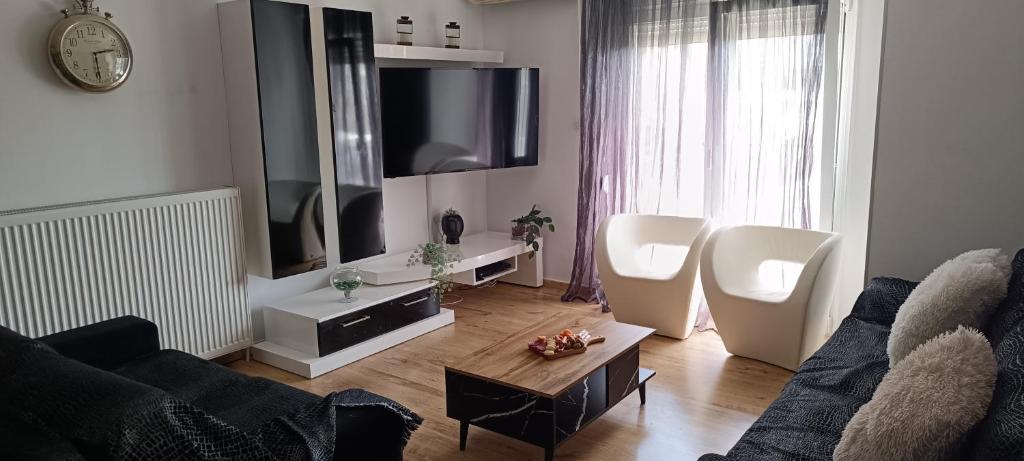 ein Wohnzimmer mit Sofa und Fernseher in der Unterkunft KilkisLuxuryApartment in Kilkís