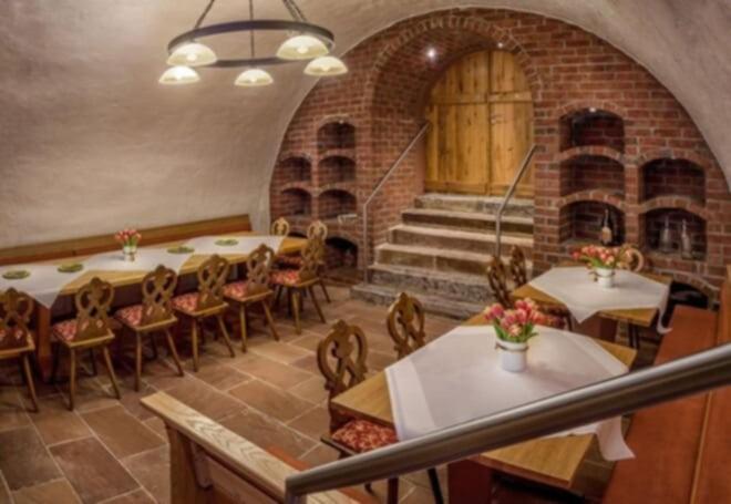 a large room with tables and chairs and a staircase at Gasthaus Krone in Weingarten
