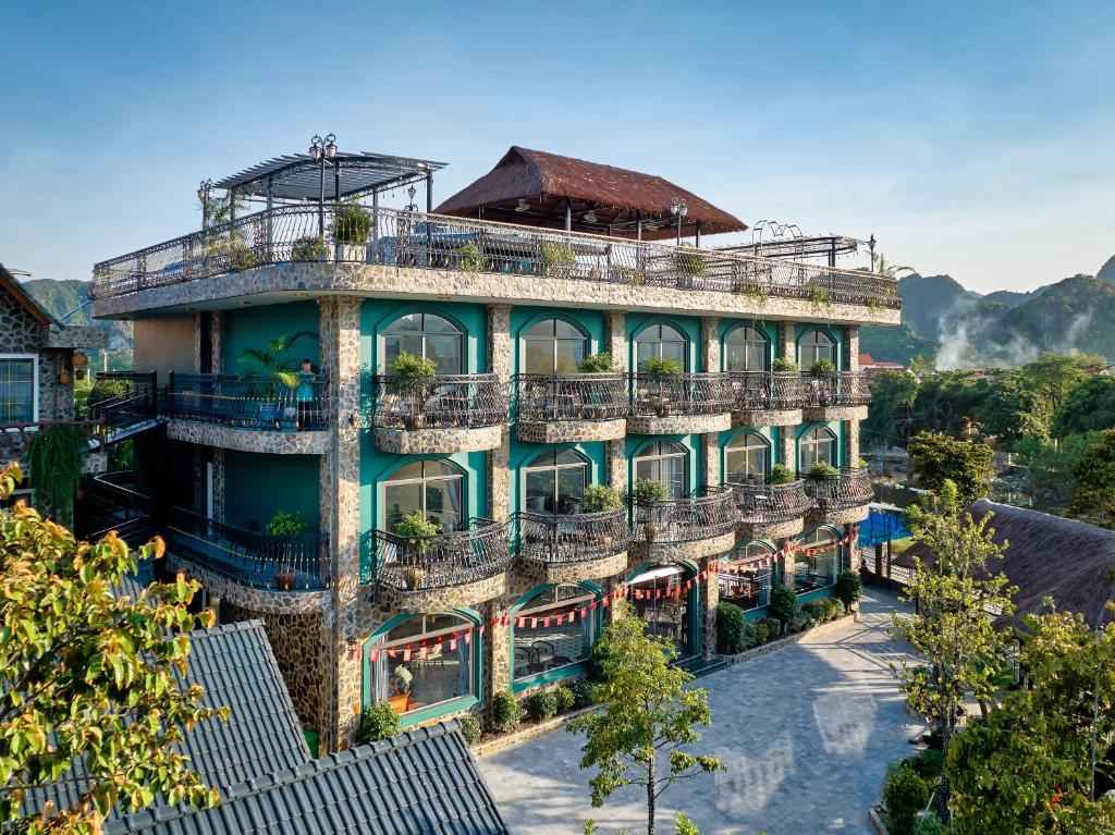a large building with balconies and trees in front of it at Tam Coc Orchid Hotel & Spa in Ninh Binh