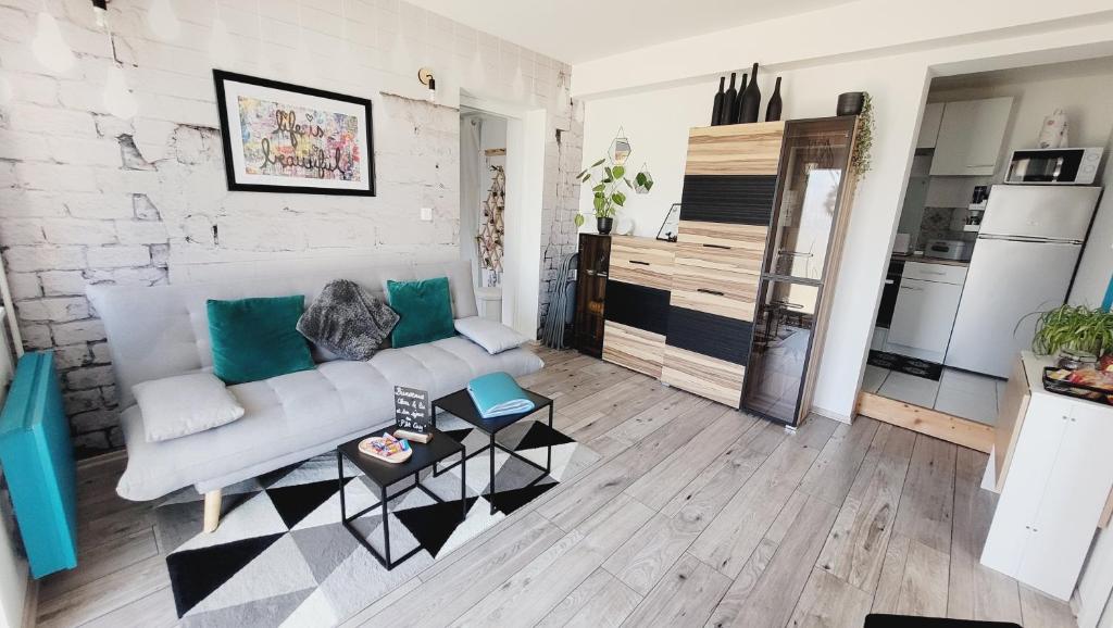 a living room with a couch and a table at Le ptit Cosy appartement privatif in Bining-lès-Rohrbach