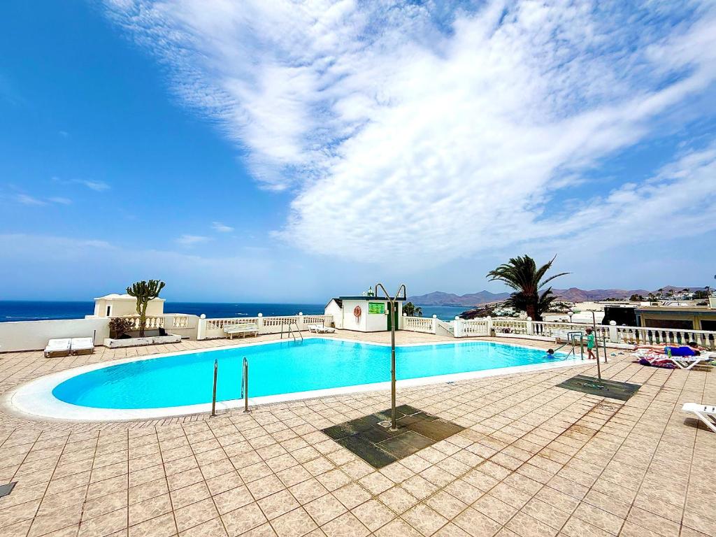 una piscina con l'oceano sullo sfondo di Rosamir Calm a Puerto del Carmen