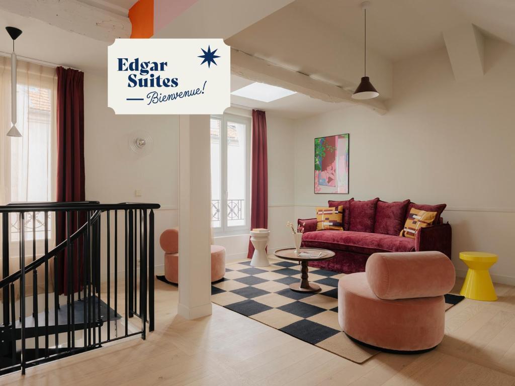 a living room with a red couch and a table at Edgar Suites - Lemercier in Paris