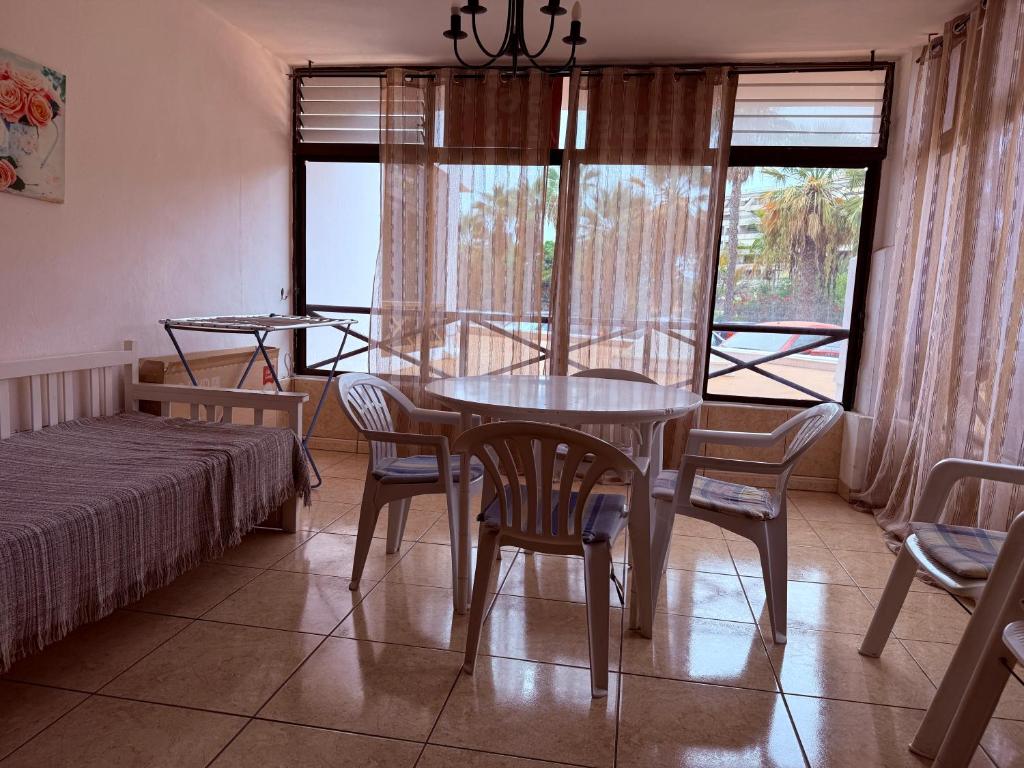 een eetkamer met een tafel en stoelen en een bed bij Lovely Los Cris Apartment in Los Cristianos