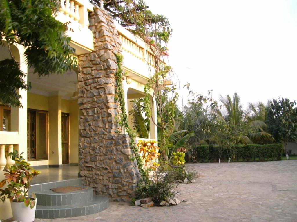 een gebouw met een stenen pilaar op een binnenplaats bij Sampson's Guesthouse Company Ltd. in Kwashieman