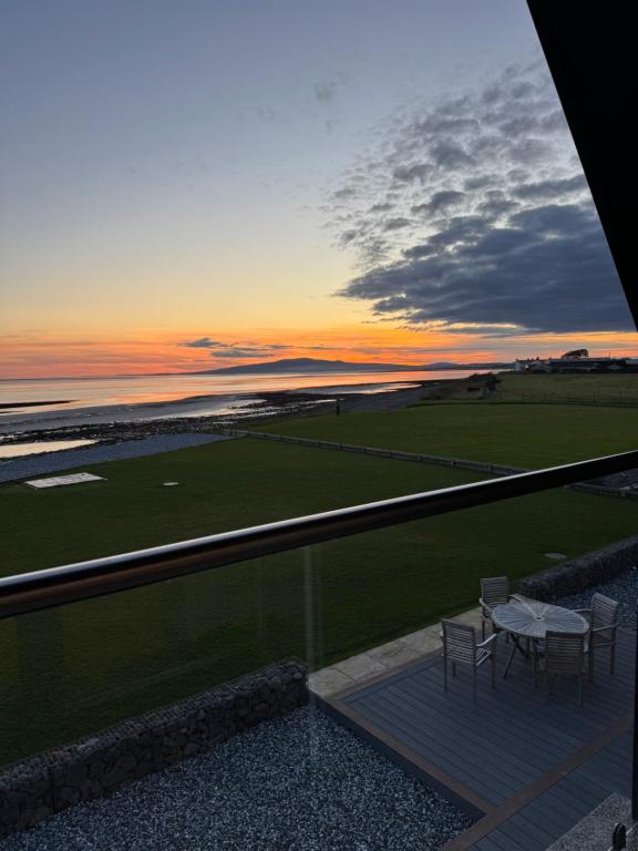 a balcony with two tables and chairs at sunset at Rumblekirn in Annan