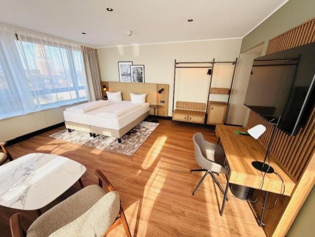 Habitación grande con cama y TV de pantalla plana. en Hotel Astor Kiel by Campanile, en Kiel