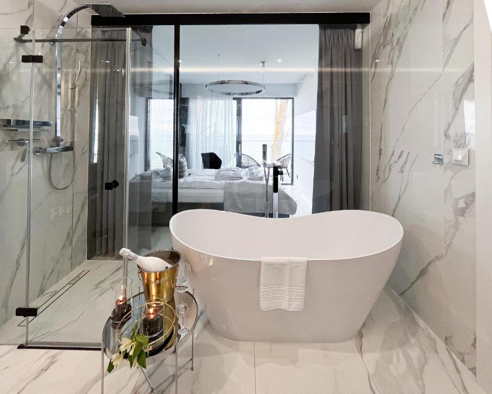 a white bath tub in a bathroom with a shower at LUX - Bath with a Baltic View Rewal - SPA Access in Rewal