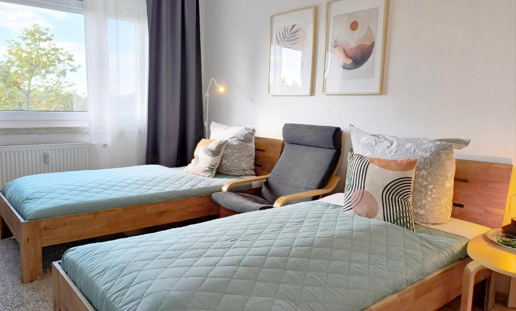 Hotel Apartment M - nice view, a small room with two beds and a chair at Apartment M - nice view in Leipzig