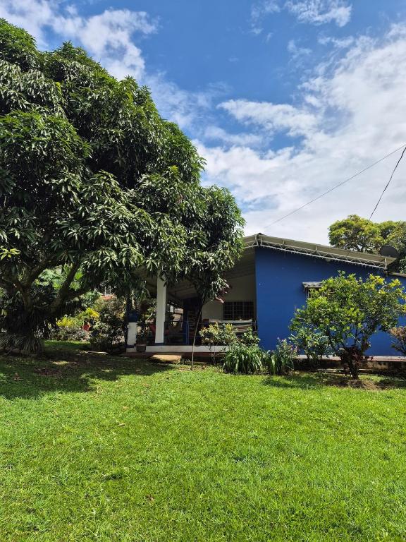a house with a blue building and a yard at Casa rustica y familiar con piscina en La Vega Cund in La Vega