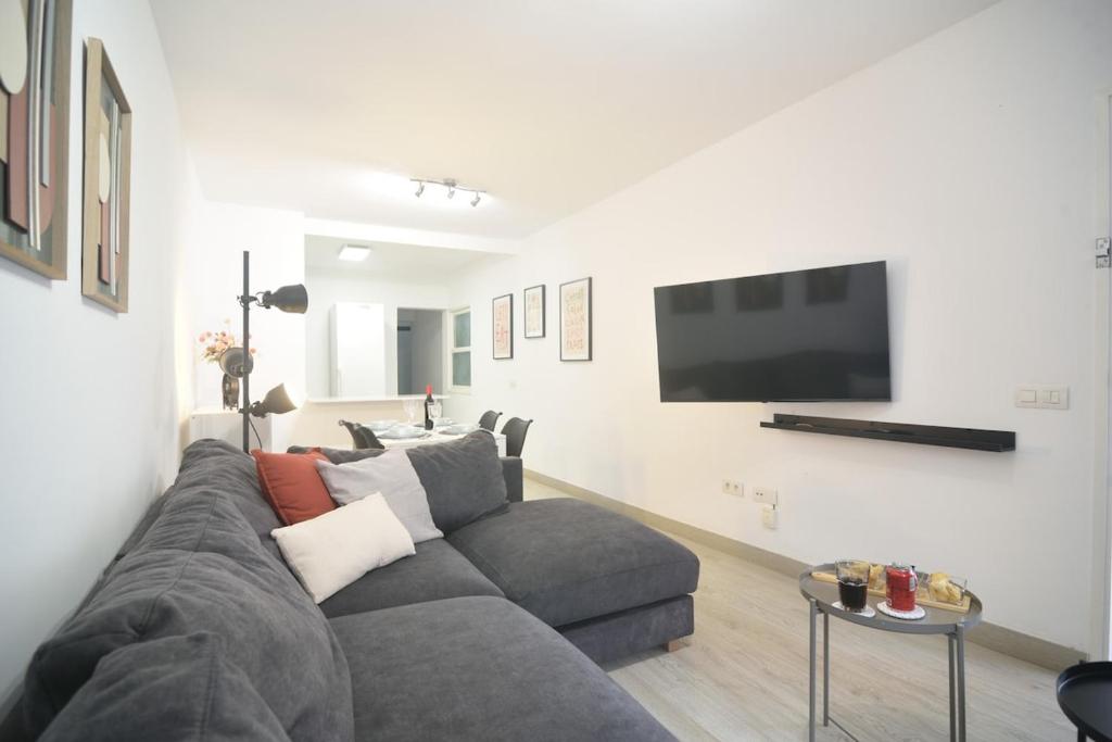 a living room with a gray couch and a flat screen tv at Casa Calma III in Tacoronte