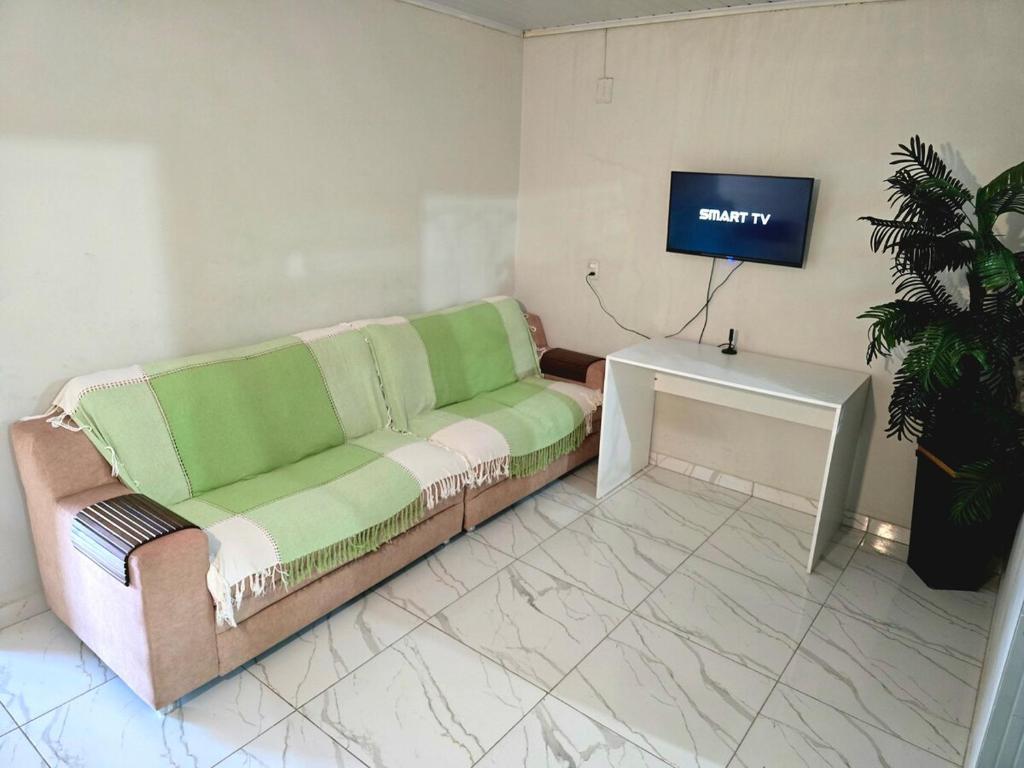 a living room with a couch and a tv at Casa Umuarama - Espaçosa e Confortável in Umuarama